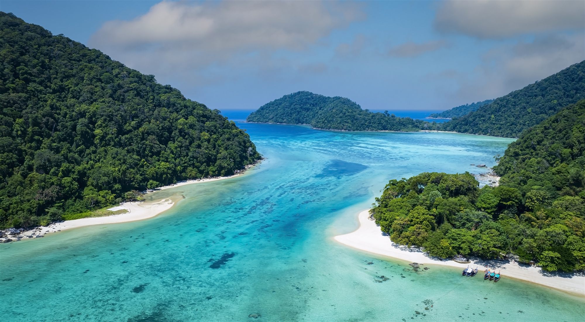Luftaufnahme der Inselwelt an Thailands Andamanenküste mit Longtail-Booten